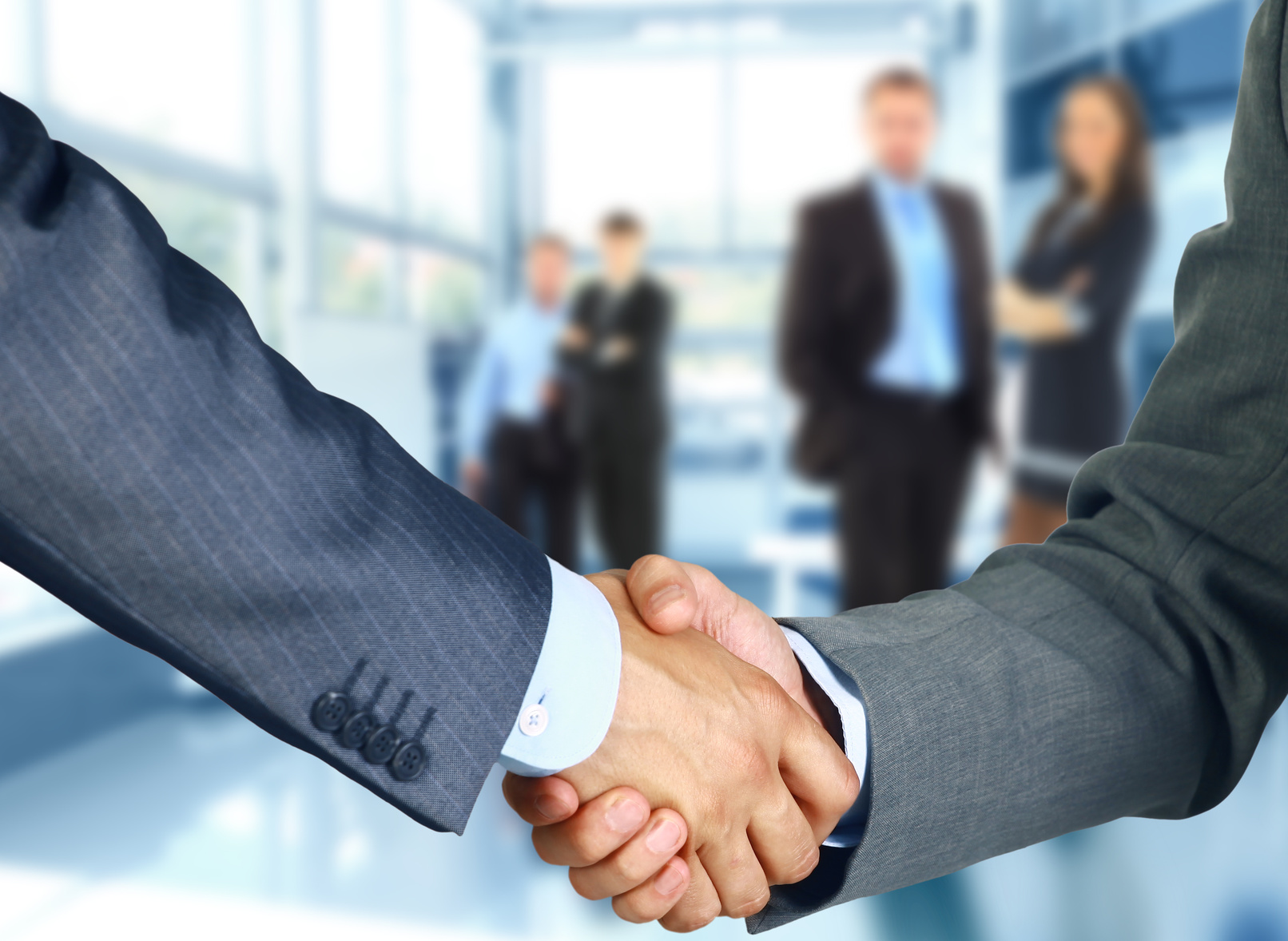 Business associates shaking hands in office Business associates shaking hands in office